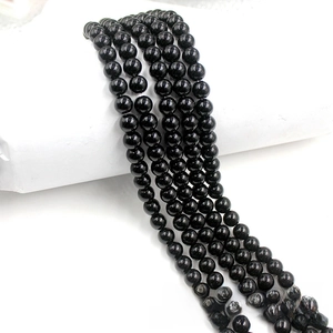 Close-up of polished black onyx glass beads with high shine finish for DIY jewelry