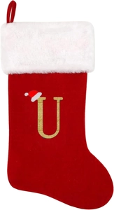 Close-up of red velvet Christmas stocking with gold glitter letter U and plush white cuff