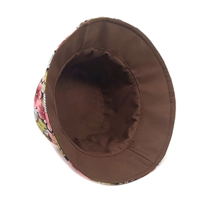 Close-up of the reversible bucket hat showing brown inner lining and floral print