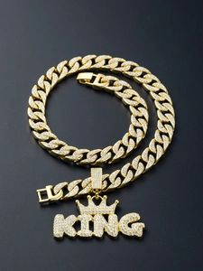 Close-up of gold Cuban chain necklace with iced-out rhinestone KING crown pendant