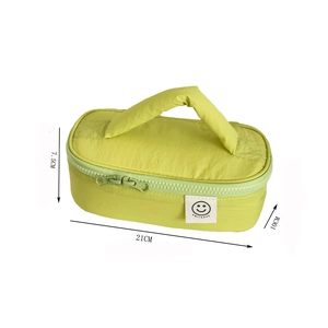 Macro view of green quilted smiley face cosmetic bag with 21x10x7.5cm dimensions