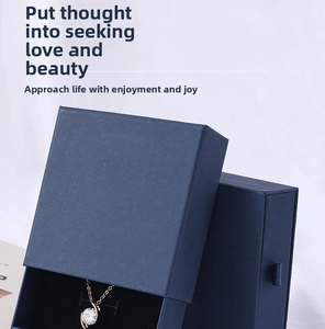 Close-up of rose gold necklace with zircon pendant inside a blue textured gift box