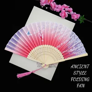 Detail of pink gradient silk folding fan with cherry blossom pattern and bamboo carving