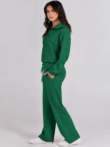 Detail view of deep green tracksuit side profile with quarter-zip top and wide-leg pants