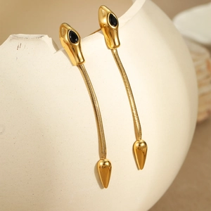 Golden snake chain earrings featuring black gemstone accents on a minimalist metal finish