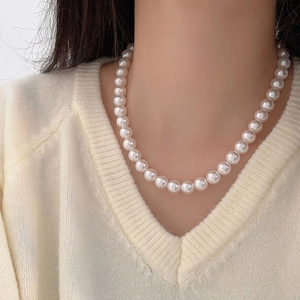 Elegant 925 sterling silver necklace featuring round 10mm white pearls on a model
