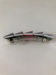 Top view of a unique metal hair clip featuring five colorful miniature books on white