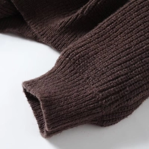 Detail shot of chunky knit sweater cuff with ribbed texture in deep coffee brown