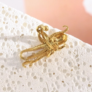 Détail du clip d'oreille tentacule de poulpe plaqué or 18K sur pierre de corail blanc