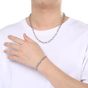 Ensemble collier et bracelet à maillons en acier inoxydable de 7mm sur un t-shirt blanc
