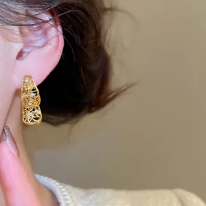 Boucles d'oreilles vintage en or avec cristaux portées sur modèle pour un look rétro