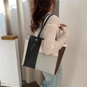 Elegante Color-Block-Einkaufstasche in Schwarz Beige und Braun am Modell in modernem Raum