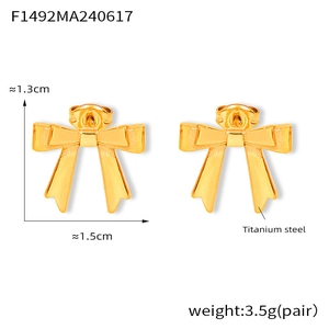 Détail de boucles d'oreilles nœud en acier titane plaqué or 18 carats avec dimensions de 1,5 cm