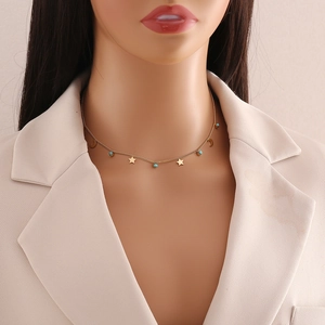 Gold necklace with turquoise beads, moon and star pendants shown on a model