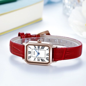 Elegant square gold watch with red leather strap and roman numeral dial on white desk