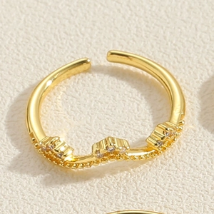 Detail eines vergoldeten Bambusrings mit funkelndem Zirkonia-Besatz und Perlenkanten