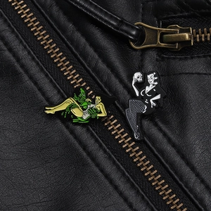 Detail of vintage horror enamel pins featuring movie monsters on a black leather jacket