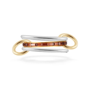 Detailed macro view of a three-piece ring set featuring gold, silver bands and red-brown stone