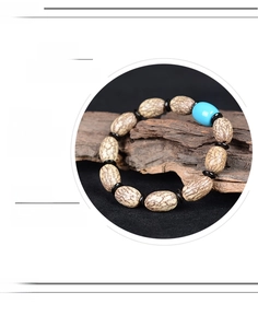 Detailsicht des Blutseiden-Bodhi-Armbands mit Türkisperle und Holz-Akzenten auf Rinde