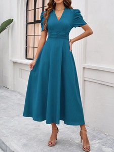 Detail view of the V-neck short sleeve design and waist of the elegant blue dress