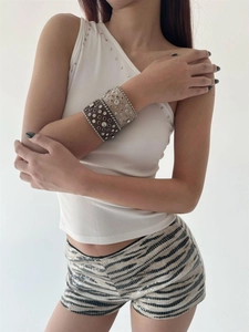 Detail of studded leather bracelets with rhinestones styled on a female model