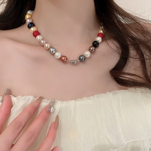 Close-up of colorful pearl necklace with glossy multi-color beads and silver clasp on neck