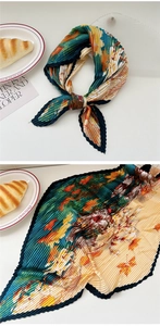 Detail of pleated silk scarf with vintage maple leaf print and elegant serrated edges