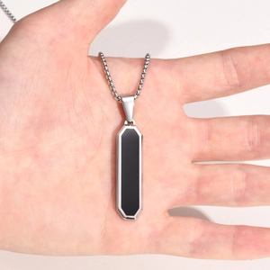 Minimalist stainless steel bar necklace with black enamel inlay held in hand