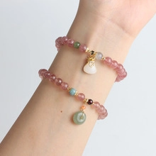 Detail of beaded gemstone bracelets with money bag and safety buckle pendants
