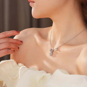 Dettaglio di una collana con ciondolo a quadrifoglio d'argento con zircone sul collo
