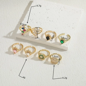 Set de 8 anillos dorados de corazón y corona con circonitas de colores y diseño geométrico