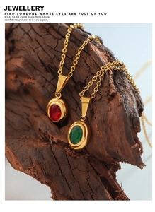 Detail of red and green gemstone oval pendants on gold-plated chains against bark texture