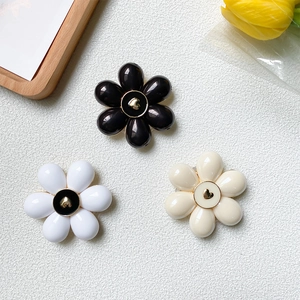 Detailed view of floral phone grips in black, white and cream with golden heart centers