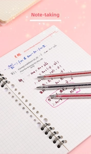Detail of three glitter gel pens with sparkling ink on a spiral notebook for journaling