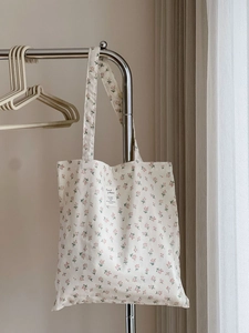 Detailed close-up of pink floral pattern and textile patch on cotton tote bag