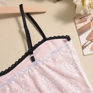 Detalle del vestido de encaje floral rosa con ribete negro y tirantes finos ajustables