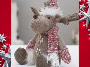 Close-up of pink Christmas plush reindeer with knitted scarf and snowflake buttons