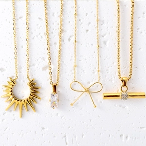 Set of four gold stainless steel necklaces featuring star, crystal, bow, and T-bar pendants