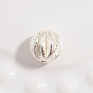 Macro shot of S925 sterling silver textured olive bead with hallmark for jewelry making