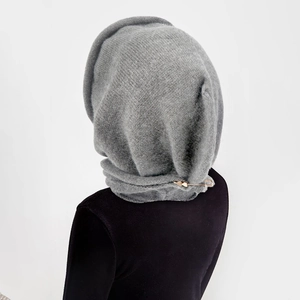 Detail of grey knitted hood scarf with a gold safety pin on premium cashmere-like fabric
