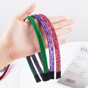 Detailed shot of flexible glitter headbands in red, purple, and green colors