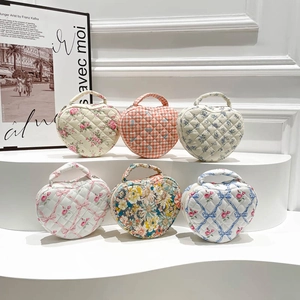 Detailed display of six heart-shaped quilted cotton makeup bags with floral and plaid patterns
