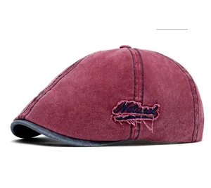Detail view of burgundy washed vintage newsboy cap with Natural embroidery and distressed holes