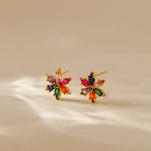 Macro shot of colorful zircon flower earrings in golden frame with high detail