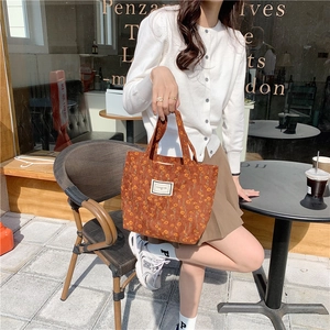 Detail shot of brown corduroy tote with floral patterns and Pleasant Time woven label
