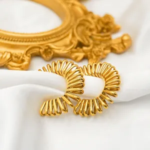Irregular 18k gold plated stainless steel spring hoop earrings on white silk surface