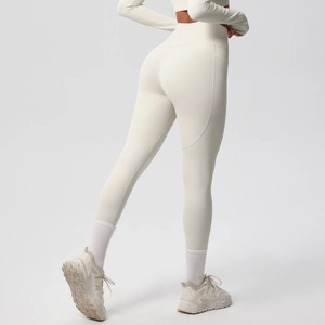 Close-up of high-waisted yoga leggings in cream white with side pockets and seamless stitching