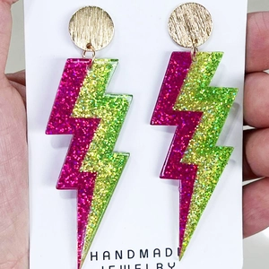 Macro detail of lightning bolt resin earrings with pink and green glitter finish