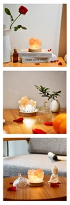 Close-up of Himalayan pink salt lamp in glass bowl with wooden base and warm orange light
