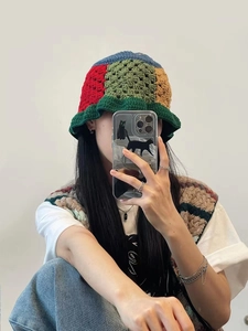 Close-up detail of multi-color crochet bucket hat and matching knit vest in mirror selfie